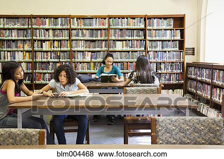 Stock Photo - People reading books in library. Fotosearch