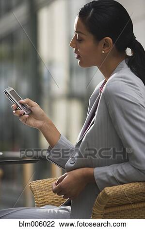 Pilipino businesswoman text messaging on cell phone View Large Photo Image Stock Image - Pilipino businesswoman text messaging on cell phone. Fotosearch