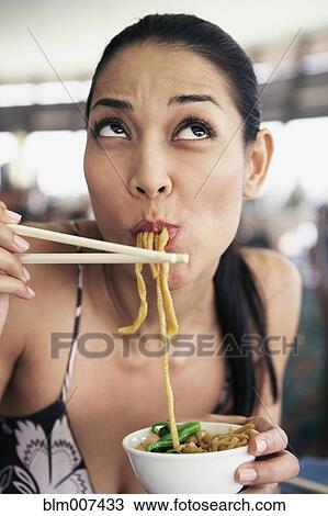 Pilipino woman eating noodles View Large Photo Image Stock Image - Pilipino woman eating noodles. Fotosearch