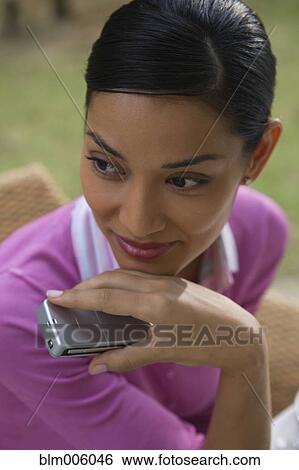 Stock Photograph - Pilipino woman holding cell phone. Fotosearch