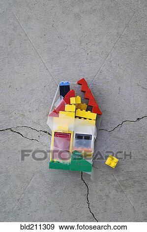 Stock Photo - Plastic block house taped together on concrete. Fotosearch
