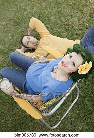 Stock Photo - Pregnant, alternative Hispanic woman sitting with husband. Fotosearch