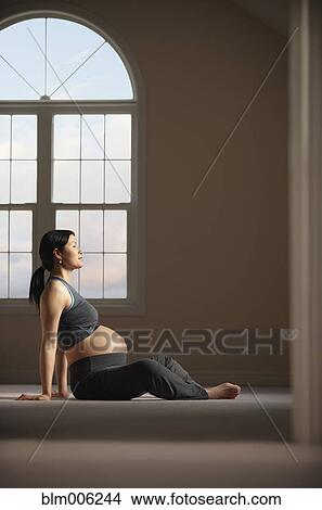 Picture - Pregnant Chinese woman doing yoga. Fotosearch