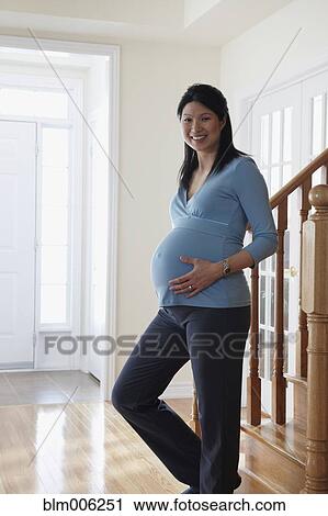 Pregnant Chinese woman holding stomach View Large Photo Image Stock Image - Pregnant Chinese woman holding stomach. Fotosearch