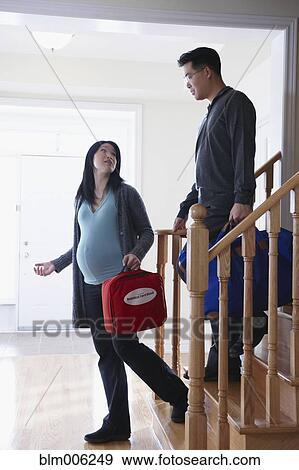 Stock Photo - Pregnant Chinese woman leaving for hospital with husband. Fotosearch