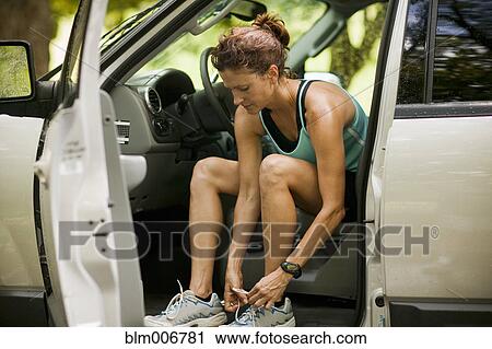 Runner sitting in car tying shoes View Large Photo Image Stock Image - Runner sitting in car tying shoes. Fotosearch
