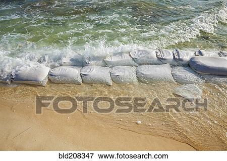 Stock Photo - Sandbags at waters edge to prevent the erosion. Fotosearch
