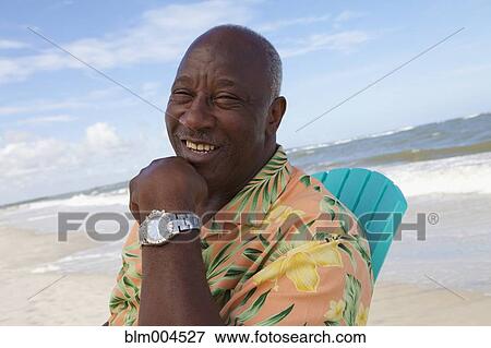 Stock Photo - Senior African man enjoying beach. Fotosearch