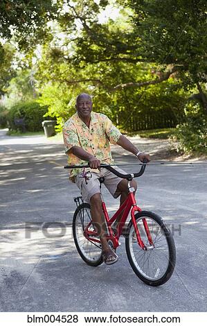 Senior African man riding bicycle View Large Photo Image Stock Photo - Senior African man riding bicycle. Fotosearch