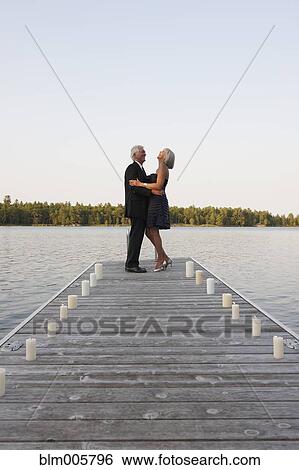 Stock Photograph - Senior Caucasian couple dancing on pier. Fotosearch