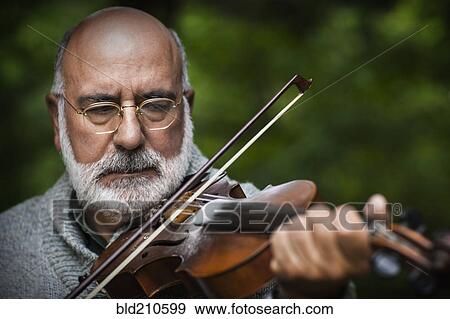 Senior Caucasian man playing violin outdoors View Large Photo Image Stock Photo - Senior Caucasian man playing violin outdoors. Fotosearch
