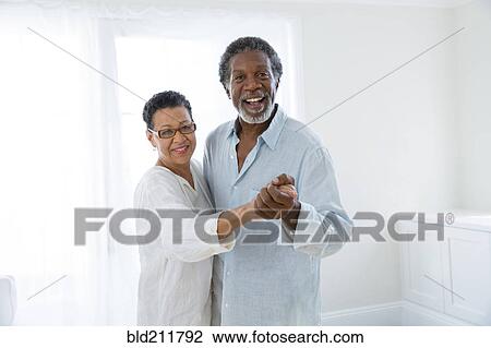 Stock Image - Senior couple dancing indoors. Fotosearch