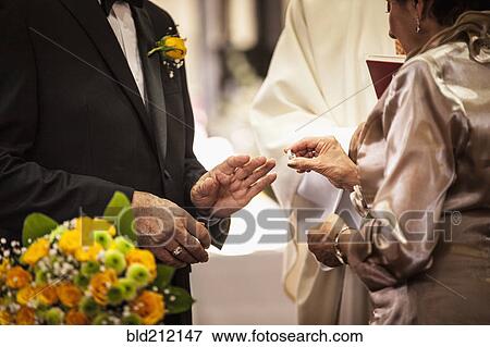 Stock Photo - Senior couple exchanging rings at wedding. Fotosearch