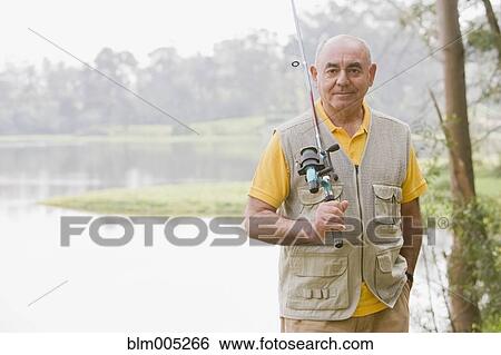 Stock Photograph - Senior Hispanic man fishing. Fotosearch