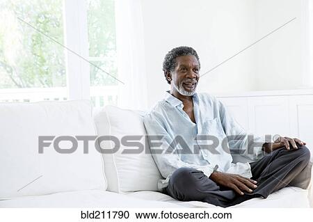 Stock Image - Senior man relaxing on sofa. Fotosearch