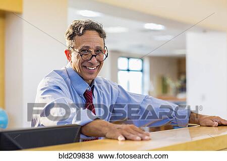 Stock Photo - Senior man smiling in library. Fotosearch