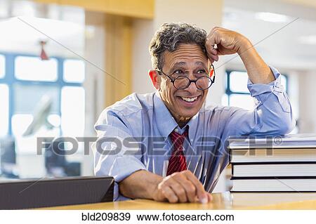 Senior man smiling in library View Large Photo Image Stock Photo - Senior man smiling in library. Fotosearch