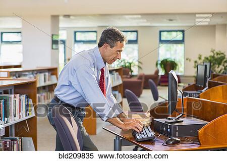 Senior man working on computer in library View Large Photo Image Stock Photography - Senior man working on computer in library. Fotosearch