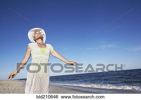 Senior woman standing on tropical beach View Large Photo Image Stock Photograph - Senior woman standing on tropical beach. Fotosearch