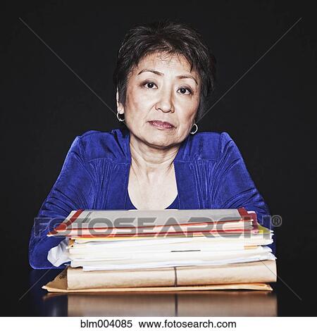 Serious Asian woman with stack of paperwork View Large Photo Image Stock Photography - Serious Asian woman with stack of paperwork. Fotosearch