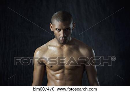 Stock Image - Serious Hispanic man with bare chest. Fotosearch