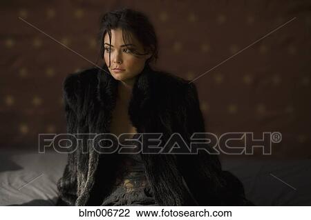 Stock Image - Serious Hispanic woman in fur coat. Fotosearch
