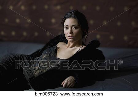 Stock Image - Serious Hispanic woman in fur coat. Fotosearch