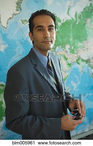 Serious Middle Eastern businessman with cell phone View Large Photo Image Stock Image - Serious Middle Eastern businessman with cell phone. Fotosearch