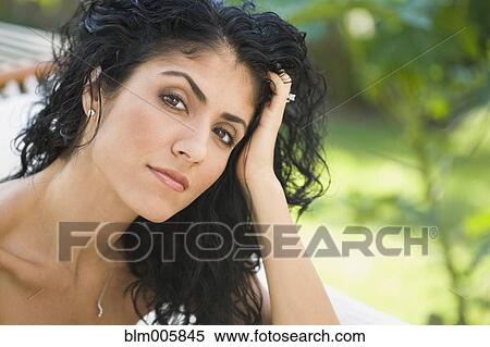 Stock Photography - Serious mixed race woman with head in hands. Fotosearch