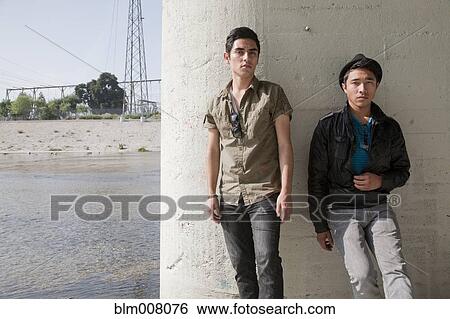 Stock Photograph - Serious teenage boys leaning against wall. Fotosearch
