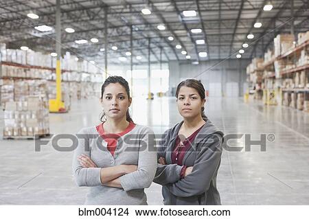 Serious women with arms crossed in warehouse View Large Photo Image Picture - Serious women with arms crossed in warehouse. Fotosearch