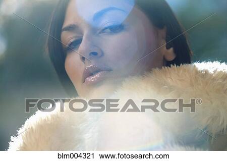 Stock Image - Sexy Hispanic woman wearing fur coat. Fotosearch
