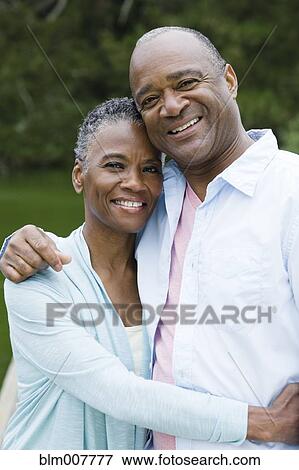 Stock Photo - Smiling African American couple hugging. Fotosearch