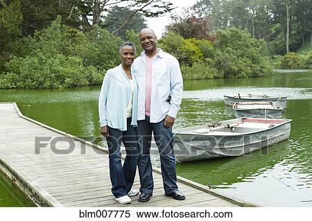 Smiling African American couple standing on pier at lake View Large Photo Image Stock Photography - Smiling African American couple standing on pier at lake. Fotosearch