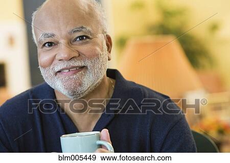 Smiling African American man drinking coffee View Large Photo Image Stock Photo - Smiling African American man drinking coffee. Fotosearch