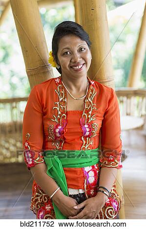 Stock Image - Smiling Balinese woman in traditional clothing. Fotosearch