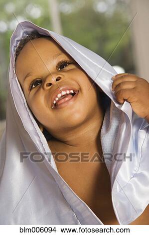 Picture - Smiling Black boy covered with blanket. Fotosearch