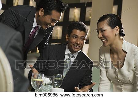 Stock Photograph - Smiling business people in restaurant. Fotosearch