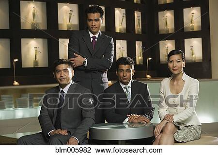 Stock Image - Smiling business people sitting in restaurant. Fotosearch