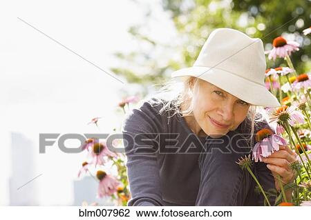 Smiling Caucasian woman holding flower View Large Photo Image Stock Image - Smiling Caucasian woman holding flower. Fotosearch