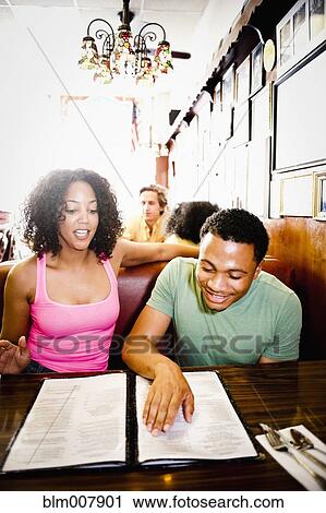 Smiling couple reading menu in diner View Large Photo Image Stock Image - Smiling couple reading menu in diner. Fotosearch