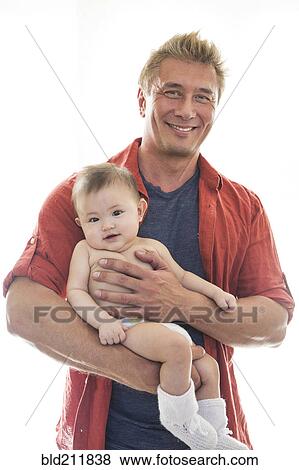 Stock Photo - Smiling father holding baby. Fotosearch