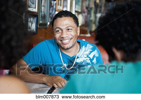 Smiling friends sitting in diner View Large Photo Image Stock Image - Smiling friends sitting in diner. Fotosearch