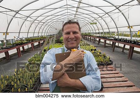 Smiling Hispanic man holding clipboard in greenhouse View Large Photo Image Stock Photography - Smiling Hispanic man holding clipboard in greenhouse. Fotosearch