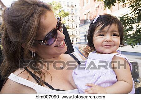Smiling Hispanic mother and daughter on urban street View Large Photo Image Stock Image - Smiling Hispanic mother and daughter on urban street. Fotosearch