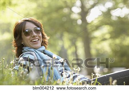 Smiling Hispanic woman laying in grass View Large Photo Image Stock Image - Smiling Hispanic woman laying in grass. Fotosearch