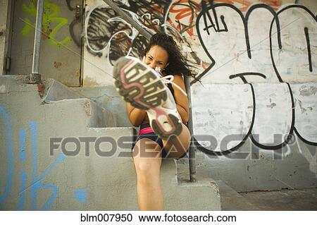 Smiling Hispanic woman on urban stairs kicking at camera View Large Photo Image Stock Image - Smiling Hispanic woman on urban stairs kicking at camera. Fotosearch