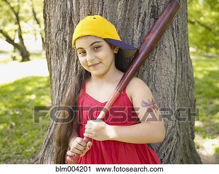Stock Image - Smiling mixed race girl holding baseball bat. Fotosearch