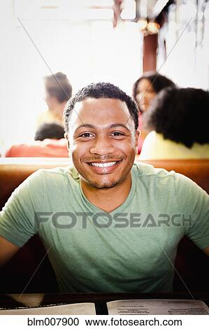 Stock Image - Smiling mixed race man in diner. Fotosearch