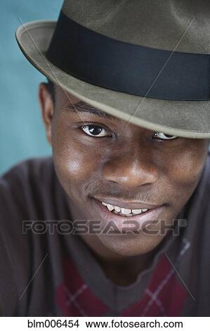 Picture - Smiling mixed race man in fedora. Fotosearch